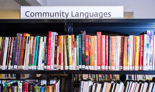 Row of community languages books in a library